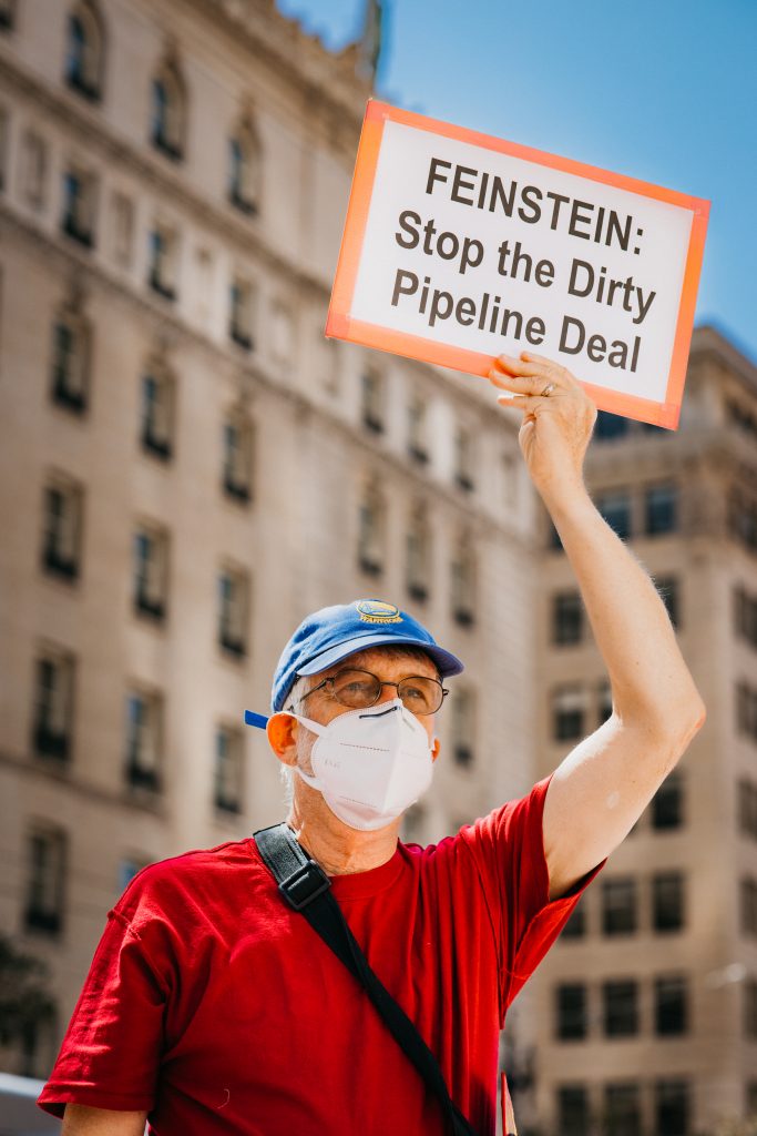 a man with a mask and sign at a protest